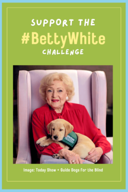 Betty White sitting in a chair with a guide dog for the blind.